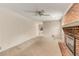 Empty living room features a brick fireplace, a ceiling fan, and access to the side yard at 2927 Ponderosa Cir, Decatur, GA 30033