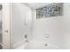 Bright bathroom featuring a soaking tub, a window for natural light, and tiled walls for easy maintenance at 3448 Great Meadows Ct, Lithonia, GA 30038