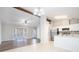 Bright living room adjacent to the kitchen, featuring hardwood floors, a beamed ceiling, and neutral paint colors at 3448 Great Meadows Ct, Lithonia, GA 30038