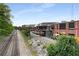 Exterior view of a brick building alongside train tracks with an overhead bridge and greenery at 913 Spencer Ave, Atlanta, GA 30318