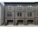 Modern townhome exteriors featuring dark gray siding and brick accents with two-car garages and contemporary lighting at 913 Spencer Ave, Atlanta, GA 30318