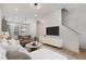 Sun-filled living room featuring hardwood floors, stairs, a TV, and modern furniture at 913 Spencer Ave, Atlanta, GA 30318