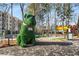 Whimsical park sculpture of a green dog on a paved walkway, surrounded by trees and shops at 913 Spencer Ave, Atlanta, GA 30318