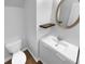 Bathroom with a white sink vanity, toilet, and round mirror at 148 Hill Side Way, Hiram, GA 30141