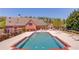 A community pool with ample lounge chairs, tables and chairs, and a building with a chimney in the background on a sunny day at 4321 Lanier Ridge Walk # 1704, Cumming, GA 30041