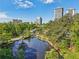 Aerial view of the community pond with mature trees and buildings in the background at 55 Delmont Ne Dr # D1, Atlanta, GA 30305