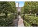 Exterior shot of a condo unit framed by manicured trees and shrubs, featuring a brick pathway leading to the front entrance at 55 Delmont Ne Dr # D1, Atlanta, GA 30305