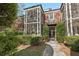 Exterior view of condo unit with a screened porch, brick facade, manicured shrubs, and a walkway leading to the entrance at 55 Delmont Ne Dr # D1, Atlanta, GA 30305