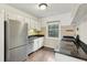 Functional kitchen with white cabinets, dark countertops, stainless steel appliances, and a window, offering a practical cooking space at 55 Delmont Ne Dr # D1, Atlanta, GA 30305