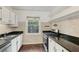 Functional kitchen with white cabinets, dark countertops, stainless steel appliances, and a window, offering a practical cooking space at 55 Delmont Ne Dr # D1, Atlanta, GA 30305