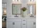 Bathroom featuring a double vanity with white cabinets and modern fixtures at 1004 Baldwin Dr, Milton, GA 30009