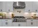 Close-up of kitchen with stainless steel stove, black countertops, and white cabinets at 1004 Baldwin Dr, Milton, GA 30009
