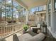 Charming porch featuring wicker furniture and views of a lush, wooded backyard at 1004 Baldwin Dr, Milton, GA 30009