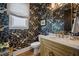 Chic powder room with designer wallpaper, a marble countertop, and stylish gold fixtures at 1004 Baldwin Dr, Milton, GA 30009