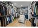 Large walk-in closet with custom shelving, hanging rods, and a sitting area at 1004 Baldwin Dr, Milton, GA 30009