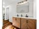Modern bathroom with double vanity, herringbone wood cabinets, and decorative mirror at 1027 Mount Airy Sw Dr, Atlanta, GA 30311