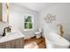 Luxurious bathroom with a soaking tub, double vanity, and modern gold finishes at 1027 Mount Airy Sw Dr, Atlanta, GA 30311