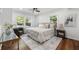 Cozy bedroom with a neutral palette, hardwood floors, ceiling fan, a decorative rug, and multiple windows at 1027 Mount Airy Sw Dr, Atlanta, GA 30311