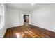 Empty bedroom with hardwood floors and view to updated kitchen through bi-fold doors at 1027 Mount Airy Sw Dr, Atlanta, GA 30311