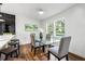 Bright dining room with a glass table, wood floors, modern decor, and two windows overlooking a verdant landscape at 1027 Mount Airy Sw Dr, Atlanta, GA 30311