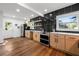 Modern kitchen with sleek black backsplash, light wood cabinets, and stainless steel appliances at 1027 Mount Airy Sw Dr, Atlanta, GA 30311