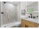 Modern bathroom with a shower, vanity, stylish mirror, and great natural light at 3107 Park Ln, Snellville, GA 30078