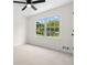 Well-lit bedroom with ceiling fan, plush carpeting, and a window with views of the lush yard at 3107 Park Ln, Snellville, GA 30078