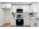 Clean kitchen featuring sleek white cabinets, stainless steel appliances, and modern finishes at 3107 Park Ln, Snellville, GA 30078