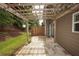 Cozy back patio with a wooden pergola and string lights; ideal for outdoor relaxation and entertaining at 5260 Sherwood Way, Cumming, GA 30040