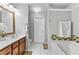 A clean bathroom featuring a soaking tub, and a wooden vanity with sink at 5260 Sherwood Way, Cumming, GA 30040
