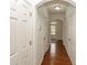 Hallway featuring hardwood floors, white trim, and access to various rooms with white doors at 5260 Sherwood Way, Cumming, GA 30040
