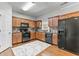 Functional kitchen with wood cabinets, black appliances, and hardwood floors at 5260 Sherwood Way, Cumming, GA 30040