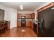 Kitchen featuring hardwood floors, granite countertops, and black appliances at 5260 Sherwood Way, Cumming, GA 30040