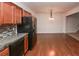 Kitchen with hardwood floors, granite counters, black appliances, open to dining area at 5260 Sherwood Way, Cumming, GA 30040