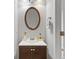 Powder room featuring vanity with storage, oval mirror and neutral wall color at 5260 Sherwood Way, Cumming, GA 30040