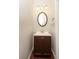 A compact powder room with a vanity and an oval mirror at 5260 Sherwood Way, Cumming, GA 30040