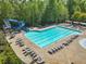 An inviting swimming pool with a waterslide and plenty of lounge chairs for relaxing at 5260 Sherwood Way, Cumming, GA 30040
