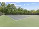 A well-maintained tennis court with professional surfacing and surrounded by lush trees at 5260 Sherwood Way, Cumming, GA 30040