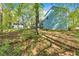 Backyard showing blue house, small shed, and wooded area with mature trees at 111 Amberwood Ln, Euharlee, GA 30145