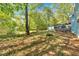 Backyard with mature trees, blue house, deck, storage shed and grassy area at 111 Amberwood Ln, Euharlee, GA 30145