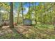 Backyard featuring mature trees, a blue storage shed, wooden deck, and a blue house at 111 Amberwood Ln, Euharlee, GA 30145