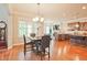 Open concept dining room with hardwood floors, stylish lighting, and views of the kitchen and living room at 2331 Kinsale Nw Pt, Kennesaw, GA 30152
