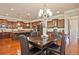 Large dining room with modern chandelier, hardwood floors, and an open view of the kitchen and living room at 2331 Kinsale Nw Pt, Kennesaw, GA 30152
