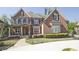 Charming two-story brick home with a manicured lawn, stone accents, and classic architectural details at 2331 Kinsale Nw Pt, Kennesaw, GA 30152
