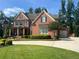 Two-story brick home with manicured lawn, and a two car garage at 2331 Kinsale Nw Pt, Kennesaw, GA 30152