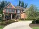 Charming two-story brick home features a landscaped yard, covered entryway, and driveway at 2331 Kinsale Nw Pt, Kennesaw, GA 30152