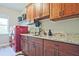 This laundry room offers granite counters, wood cabinets, a sink, and storage space at 2331 Kinsale Nw Pt, Kennesaw, GA 30152