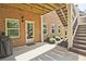 Covered patio space with brick wall, access door, and stairs leading to the upper level at 2331 Kinsale Nw Pt, Kennesaw, GA 30152