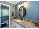 Bathroom featuring granite countertop, decorative mirror, and overhead lighting at 3397 Old Jonesboro Rd, Hapeville, GA 30354