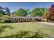 Charming brick home with a lush green lawn, mature trees, and well-maintained landscaping at 3397 Old Jonesboro Rd, Hapeville, GA 30354